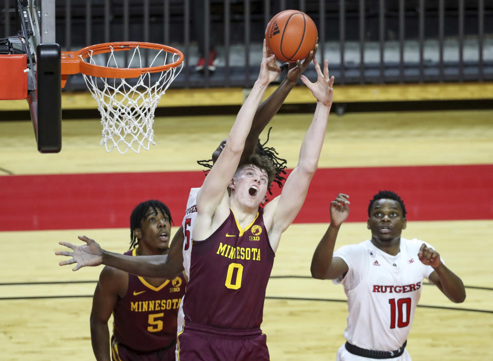 Minnesota center Liam Robbins (0) competes for a rebound with Rutgers center Cliff Omoruyi (5, obscured) during the first half of an NCAA college basketball game Thursday, Feb. 4, 2021, in Piscataway, N.J. (Andrew Mills/NJ Advance Media via AP)