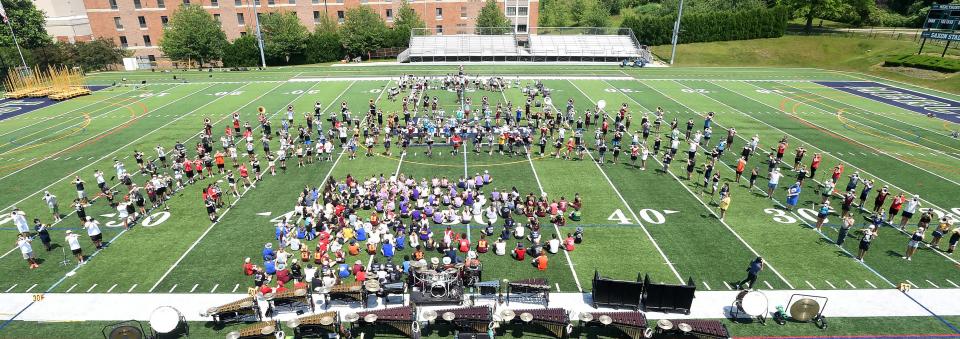 Members of The Cadets drum corps and high school band members perform together during a clinic at Mercyhurst University in Erie on June 24, 2023.