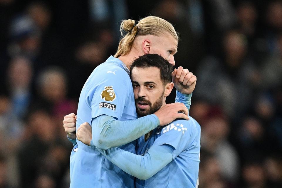 Erling Haaland and Bernardo Silva embrace after the Norwegian’s goal against Brentford (AFP via Getty Images)