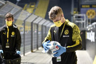 Ball boys disinfect the footballs before the German Bundesliga soccer match between Borussia Dortmund and Schalke 04 in Dortmund, Germany, Saturday, May 16, 2020. The German Bundesliga becomes the world's first major soccer league to resume after a two-month suspension because of the coronavirus pandemic. (AP Photo/Martin Meissner, Pool)