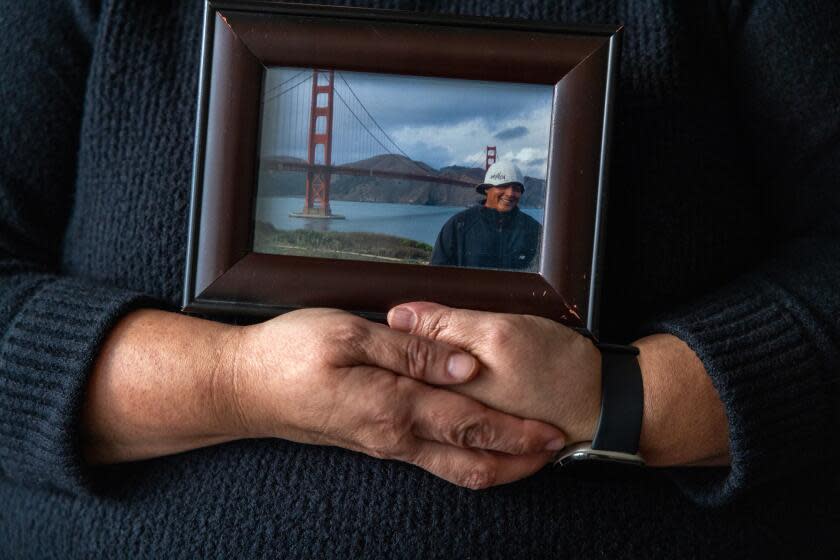 Los Angeles, CA - July 13: Portrait of Sandra Munoz, a celebrated civil rights attorney in Los Angeles. She is holding a photo of her husband Luis on January 3, 2024, in Los Angeles, CA. They have been separated since 2015. Luis, who was undocumented, applied for a waiver of his illegal entry to seek citizenship after they got married. The final step was considered a formality -- he would go back to El Salvador for an interview at the U.S. consulate there and fly back to the U.S. once it was approved. Instead, it was denied. When their lawyers pressed the government for why, the State Department admitted that his tattoos -- of La Virgen de Guadalupe, a tribal design and theatrical masks -- were among the reasons they had found him to be an MS-13 gang member, an assertion he vehemently denies. Last year, the 9th Circuit sided with the couple, but the Biden administration appealed to the Supreme Court. The high court is expected to decide next month whether to take up the case, which would have ripple effects for any immigrant seeking to challenge the government's views of their character. (Francine Orr / Los Angeles Times)