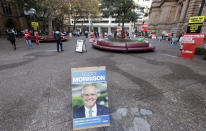 A placard with the face of Australian Prime Minister Scott Morrison is placed near the entrance of Town Hall as voters line up to cast their ballots in a federal election Sydney, Australia, Saturday, May 18, 2019. Polling stations have opened in eastern Australia on Saturday in elections that are likely to deliver the nation's sixth prime minister in as many years. (AP Photo/Rick Rycroft)