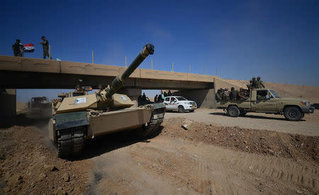 A tank of Iraqi army members and Shi'ite Popular Mobilization Forces (PMF) are seen in Al-Al-Fateha military airport south of Hawija, Iraq, October 2, 2017. REUTERS/Stringer