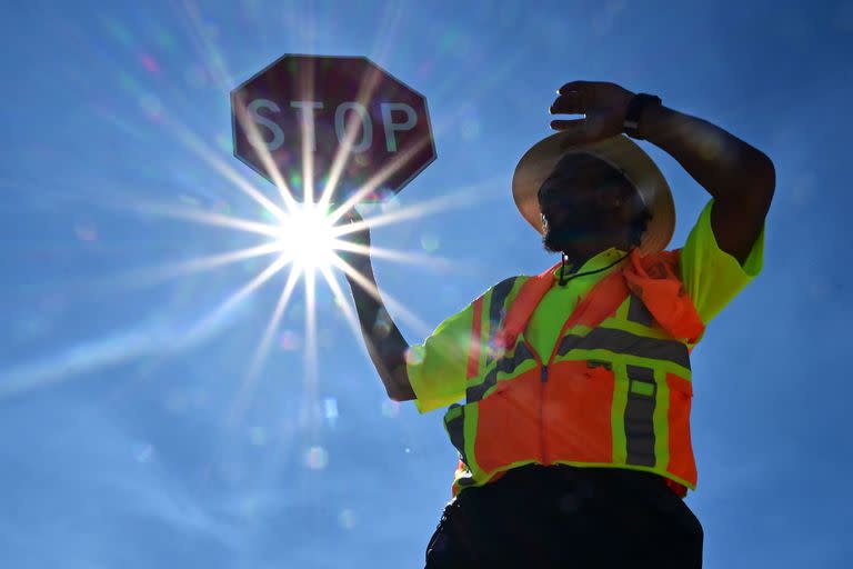 El guardia de tráfico Rai Rogers vigila la esquina de su calle durante un turno de 8 horas bajo un sol abrasador en Las Vegas, Nevada, el 12 de julio de 2023, donde las temperaturas alcanzaron los 106 grados en medio de una ola de calor.