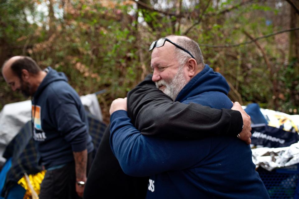 David Ward, who has spearheaded a local effort to help people who are homeless, hugs a man.