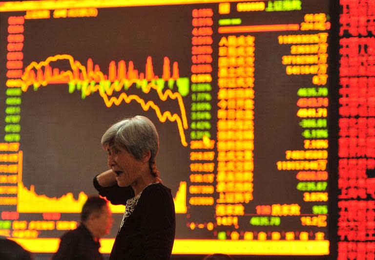A stock investor gestures as she checks share prices at a securities firm in Fuyang