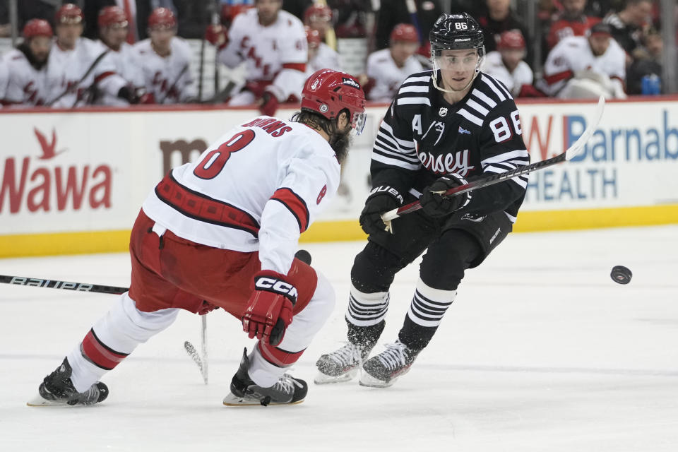 New Jersey Devils center Jack Hughes (86) skates against Carolina Hurricanes defenseman Brent Burns (8) during the second period of an NHL hockey game, Saturday, March 9, 2024, in Newark, N.J. (AP Photo/Mary Altaffer)