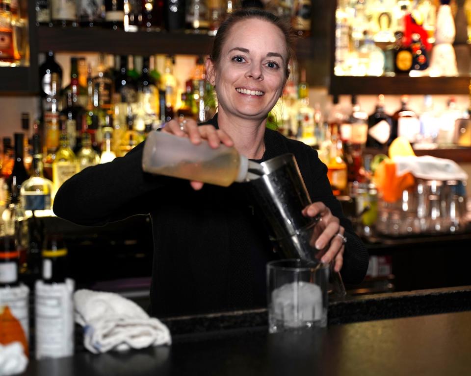 Lorrain Leibfarth, assistant bar manager at Chaloner’s Cigar House and Store in downtown Adrian, mixes a gin drink called “Walk with Juniper” March 10. Chaloner & Co. is one of several downtown Adrian establishments that is increasing its employment for the summer months.