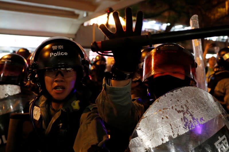 Riot police members shout as they carry a detained protester outside a shopping mall in Tai Po in Hong Kong
