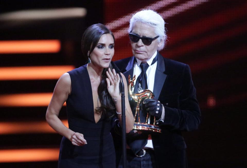 Victoria Beckham is awarded a Bambi trophy Karl Lagerfeld in Berlin, 2013 (AP Photo/dpa, Michael Kappeler)