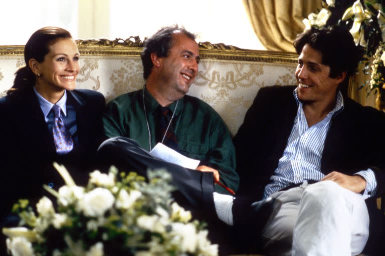 Roger Michell rodeado por Julia Roberts y Hugh Grant, los protagonistas de Un lugar llamado Notting Hill, la película que le dio fama y prestigio al director que murió este miércoles a los 65 años