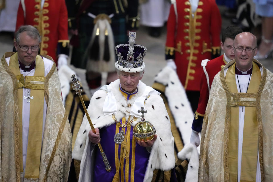 El rey Carlos III de Gran Bretaña, centro, camina en la procesión de coronación después de su ceremonia de coronación en la Abadía de Westminster en Londres el sábado 6 de mayo de 2023. (Foto AP/Kirsty Wigglesworth, Pool)
