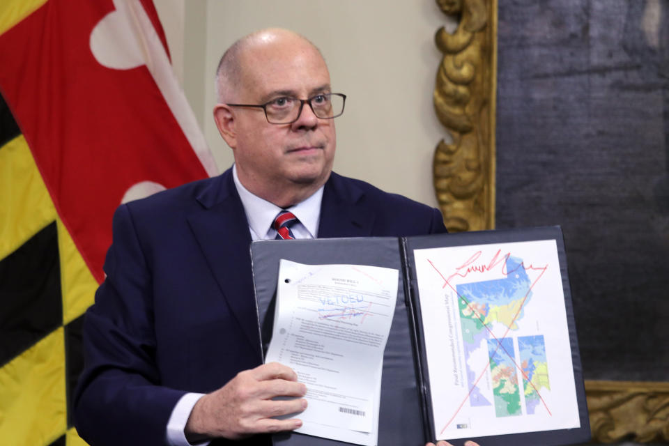 FILE - Maryland's Republican Gov. Larry Hogan shows a copy of the redrawn congressional map approved by the General Assembly, right, that is crossed out in red, during a news conference where he announced his veto of the plan, on Dec. 9, 2021, in Annapolis, Md. Campaigns for Congress already are underway for this year's elections, but lingering disagreements over the final shape of new voting districts has left some candidates, and would-be candidates, in limbo. (AP Photo/Brian Witte, File)