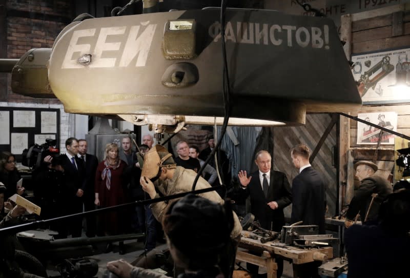 Russian President Vladimir Putin visits an exhibition depicting an armament repair shop at 3D panorama 'Memory speaks. The road through the war' in St.Petersburg