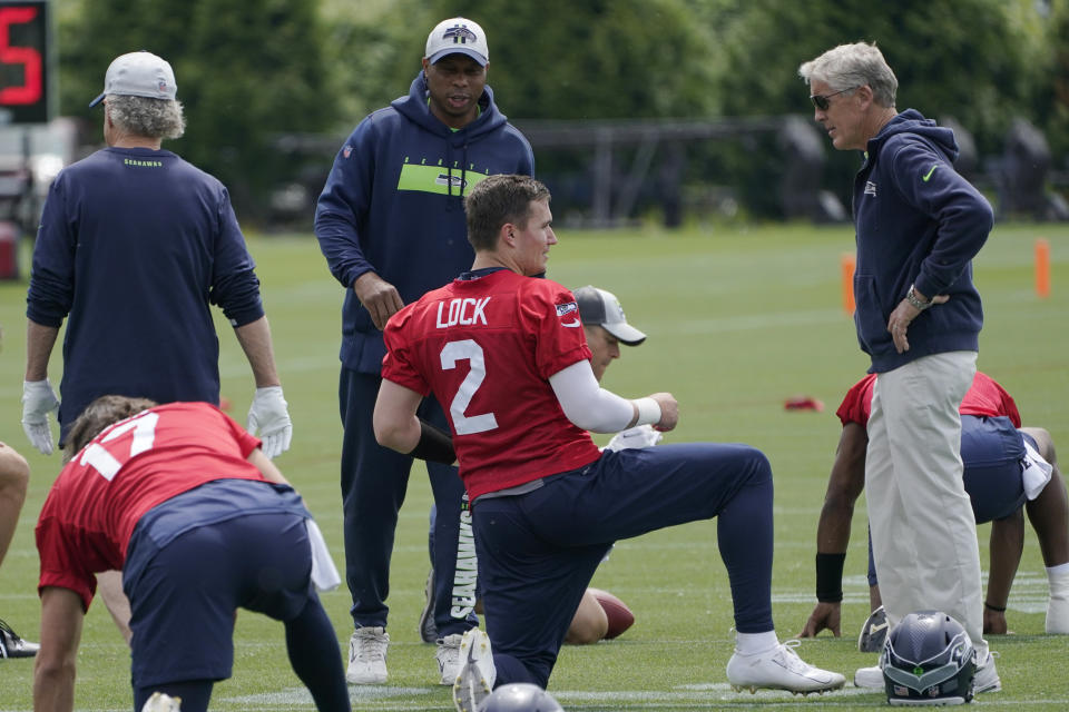 Seattle Seahawks coach Pete Carroll, right, and assistant quarterbacks coach Kerry Joseph, center, talk with quarterback Drew Lock (2) during NFL football practice Wednesday, June 8, 2022, in Renton, Wash. (AP Photo/Ted S. Warren)