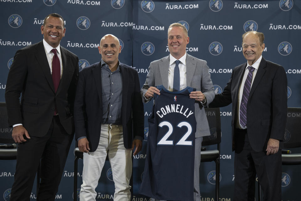 Minnesota Timberwolves Ownership Group Alex Rodriguez, left, Marc Lore,, second from left, and Glen Taylor, right, pose for a photo with Timberwolves new President of Basketball Operations Tim Connelly (holding jersey) in Minneapolis, Tuesday, May 31, 2022. (Jerry Holt/Star Tribune via AP)