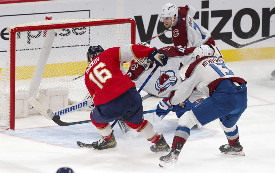 Florida Panthers center Aleksander Barkov (16) directs the puck into the net past the reach of Colorado Avalanche goaltender Alexandar Georgiev (40), right wing Valeri Nichushkin (13) and defenseman Devon Toews (7) during the third period of an NHL hockey game Saturday, Feb. 11, 2023, in Sunrise, Fla. (AP Photo/Reinhold Matay)