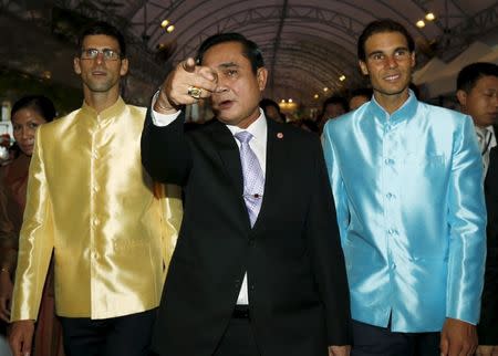 Thai Prime Minister Prayut Chan-o-cha (C) shows the way to tennis players Novak Djokovic (L) of Serbia and Rafael Nadal (R) of Spain as they visit a fair outside the Government House in Bangkok, Thailand, October 2, 2015. REUTERS/Rungroj Yongrit/Pool