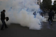Demonstrators walk through tear gas grenades fired by police forces during a banned protest in support of Palestinians in the Gaza Strip, Saturday, May, 15, 2021 in Paris. Marches in support of Palestinians in the Gaza Strip were being held Saturday in a dozen French cities, but the focus was on Paris, where riot police got ready as organizers said they would defy a ban on the protest. (AP Photo/Michel Euler)