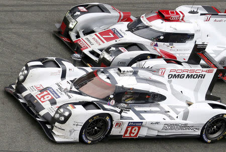 Nick Tandy of Britain drives his Porsche 919 Hybrid number 19 ahead the Audi R18 e-tron quattro number 7 driven by Marcel Fassler of Switzerland, during the Le Mans 24 Hours sportscar race in Le Mans, central France June 14, 2015. REUTERS/Regis Duvignau/File Photo