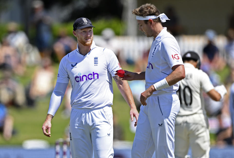 England's Ben Stokes, left, talks with bowler Stuart Broad while playing New Zealand on the second day of their cricket test match in Tauranga, New Zealand, Friday, Feb. 17, 2023. (Andrew Cornaga/Photosport via AP)