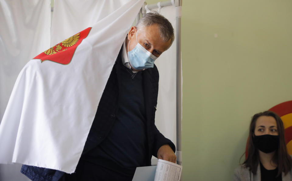Alexander Drozdenko, governor of Leningrad Region wearing a face mask to protect against coronavirus infection leaves a voting booth at a poling station during Leningrad region's governor and municipal elections in Luppolovo village, outside St. Petersburg, Russia, Sunday, Sept. 13, 2020. Leningrad region is the territory surrounding St. Petersburg. Elections are being held to choose governors and legislators in about half of Russia's regions. (AP Photo/Dmitri Lovetsky)