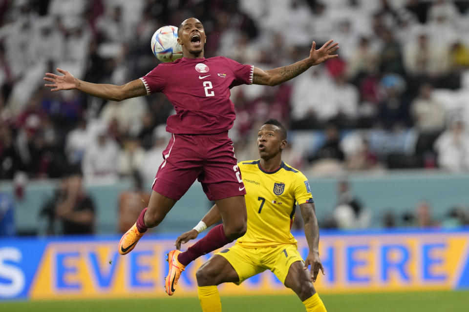 Qatar's Pedro Miguel, left, challenges for the ball with Ecuador's Pervis Estupinan during the World Cup group A soccer match between Qatar and Ecuador at the Al Bayt Stadium in Al Khor, Qatar, Sunday, Nov. 20, 2022. (AP Photo/Darko Bandic)