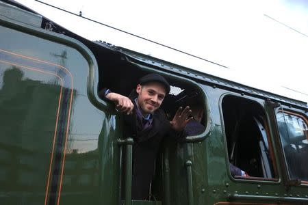 A man waves from on board the Flying Scotsman steam engine leaves Kings Cross station in London, February 25, 2016. REUTERS/Paul Hackett