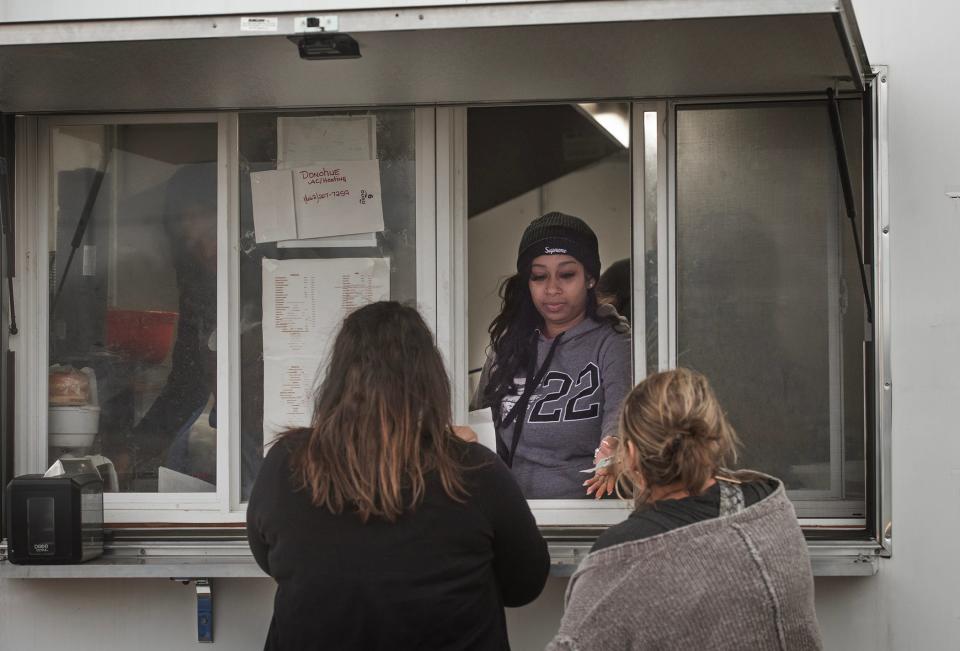 Imani Barnes of Rolling Fork, Miss., serves lunch to customers at the Chuck’s Dairy Bar food trailer on Hwy. 61 in Rolling Fork, Miss., Monday, Jan. 8, 2024. The trailer sits in the parking lot of Chuck's, being rebuilt after the March tornado wiped the building out.