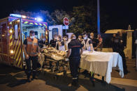 A police officer, right, secures the evacuation of an injured man after a violent brawl, in the Paris suburb of Villiers-le-Bel, Tuesday, June, 15, 2021. Police who patrol the tough suburbs north of the French capital say they feel that violence is ticking upward. Fights between rival groups are a long-standing problem in the Paris region's depressed neighborhoods, and police say they're increasingly bloody. (AP Photo/Lewis Joly)