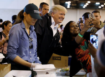 U.S. President Donald Trump poses for a photo as he and first lady Melania Trump help volunteers hand out meals during a visit with flood survivors of Hurricane Harvey at a relief center in Houston, Texas, U.S., September 2, 2017. REUTERS/Kevin Lamarque