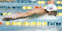 Michael Phelps competes in the 100-meter butterfly during the Arena Grand Prix swim meet, Thursday, April 24, 2014, in Mesa, Ariz. It is Phelps' first competitive event after a nearly two-year retirement. (AP Photo/Matt York)