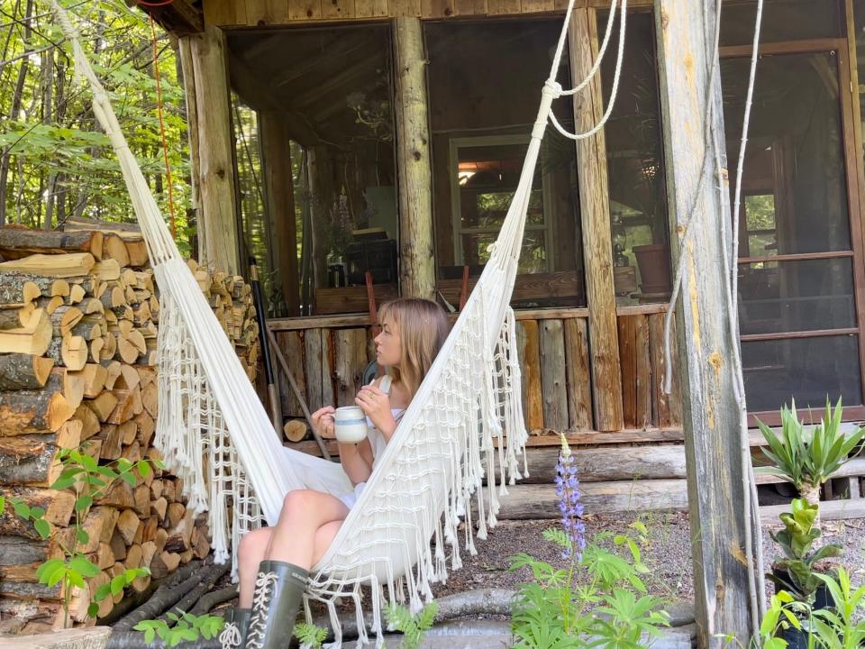 Duggan sitting on a hammock outside her cottage.