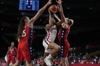 France's Sandrine Gruda (7), center, drives to the basket between United States' Brittney Griner (15), left, and Breanna Stewart (10), right, during women's basketball preliminary round game at the 2020 Summer Olympics, Monday, Aug. 2, 2021, in Saitama, Japan. (AP Photo/Eric Gay)