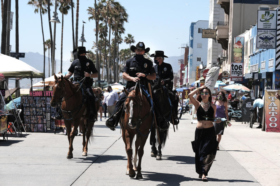 Los Angeles Police officers on horseback patrol the strand along Venice Beach on Friday, July 3, 2020, in Los Angeles. Gov. Gavin Newsom is urging Californians to use common sense over the Fourth of July weekend by wearing face masks and avoiding traditional gatherings with family and friends. (AP Photo/Richard Vogel)