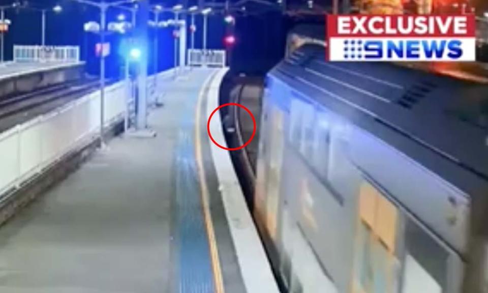 The passenger can be seen squeezing under the platform as the train arrives. Source: Nine News