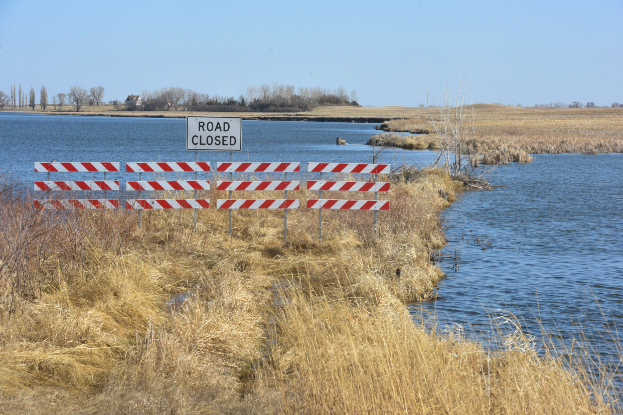 A road closed barrier blocks the entrance to a flooded road near Waubay, South Dakota on Wednesday, May 3, 2023. Gov. Kristi Noem signed an executive order to declare a disaster exists in 10 counties and on Lake Traverse Indian Reservation as a result of springtime flooding.
