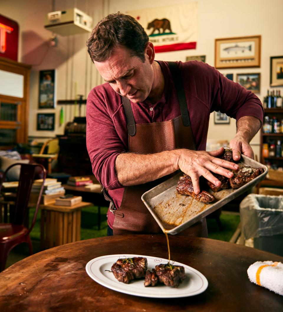 Chef Adam Perry Lang pours a post-marinade over seared meat. (Photo: Josh Telles)