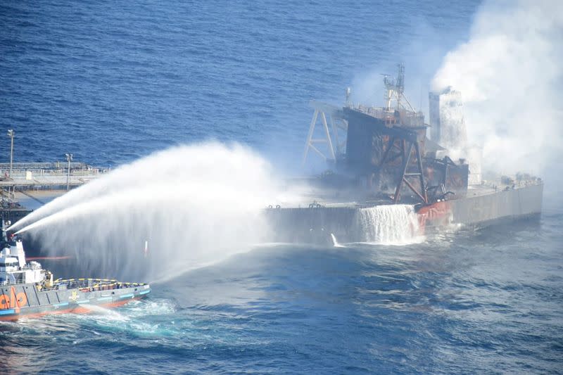 A Sri Lankan Navy boat sprays water on the New Diamond, a very large crude carrier (VLCC) chartered by Indian Oil Corp (IOC), that was carrying the equivalent of about 2 million barrels of oil, after a fire broke out off east coast of Sri Lanka