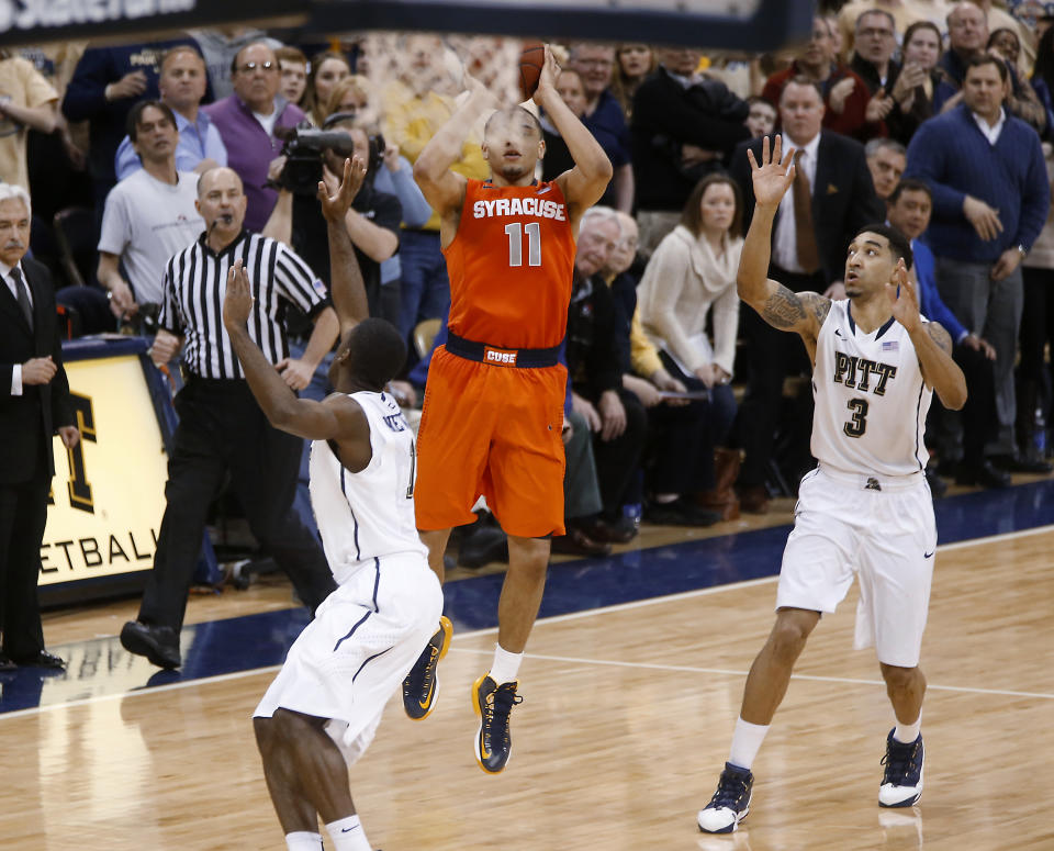 Syracuse's Tyler Ennis (11) shoots 3-pointer between Pittsburgh's Cameron Wright (3) and Josh Newkirk, left, in the final second of an NCAA college basketball game Wednesday, Feb. 12, 2014, in Pittsburgh. The shot went in and Syracuse won 58-56. (AP Photo/Keith Srakocic)