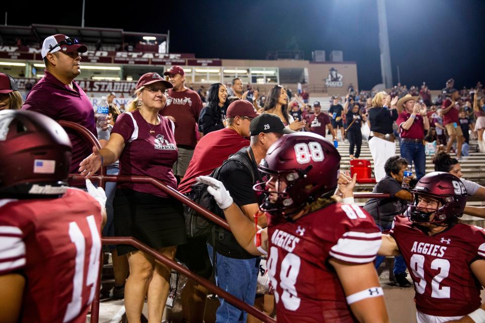 NMSU fans high-five NMSU football players after their win against Hawai'i on Saturday, Sept. 24, 2022, at the Aggie Memorial Stadium.