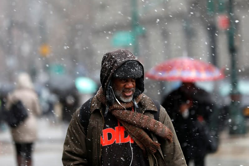 People make their way through falling snow in lower Manhattan in New York