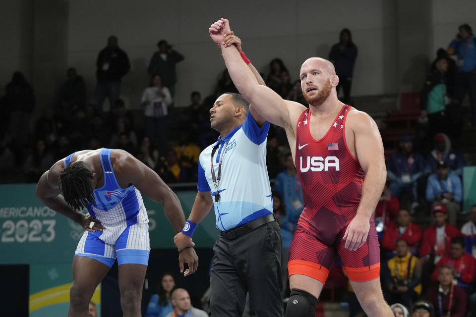 Kyle Snyder de los Estados Unidos, derecha, celebra luego de ganar la medalla de oro al vencer al cubano Arturo Silot, en los 97kg de lucha en los Juegos Panamericanos de Santiago, Chile, el miércoles 1 de noviembre de 2023.