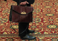 A man holds his briefcase while waiting in line during a job fair in Melville, New York July 19, 2012. The number of Americans filing new claims for unemployment benefits rebounded last week, returning to levels consistent with only modest job growth after a seasonal quirk caused a sharp drop the prior period. REUTERS/Shannon Stapleton (UNITED STATES - Tags: BUSINESS EMPLOYMENT)