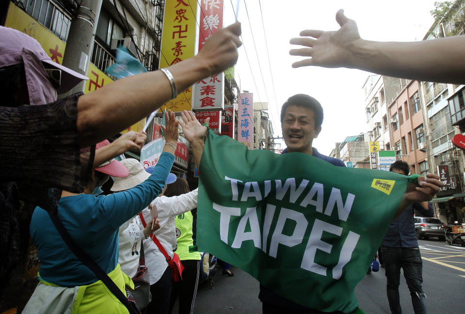 In this photo taken Saturday, Nov. 3, 2018, supporters cheer and hold a banner with the slogan "Taiwan Taipei" during a rally for a referendum asking if national teams, including ones for the Olympics, should go by the name "Taiwan Taipei" instead of "Chinese Taipei" in Taipei, Taiwan. Taiwan will vote on a referendum this month asking if the self-ruled island should compete as “Taiwan” instead of the present “Chinese Taipei.” This would include the 2020 Olympics in Tokyo. The controversial referendum has angered China, which sees Taiwan as a breakaway province. (AP Photo/Chiang Ying-ying)