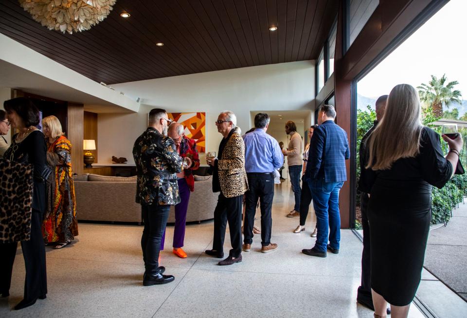 Guests mingle during a party at Frank Sinatra's Twin Palms estate held in tribute to Sinatra’s friend, American film and dance star Gene Kelly, in Palm Springs, Calif., Saturday, Feb. 26, 2022.