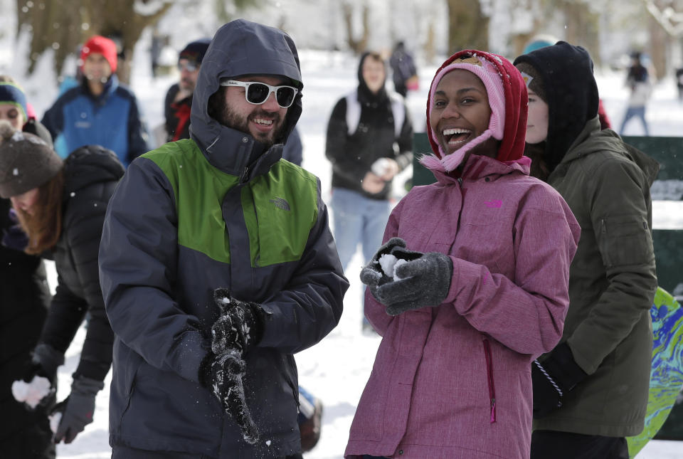 People taking part in a public snowball fight react after throwing a snowball, Saturday, Feb. 9, 2019, at Wright Park in Tacoma, Wash. Hundreds of people showed up after word of the friendly battle spread on social media Friday night and Saturday, as a winter storm that blanketed Washington state with snow moved south into Oregon and meteorologists warned that yet more winter weather was on the way. (AP Photo/Ted S. Warren)