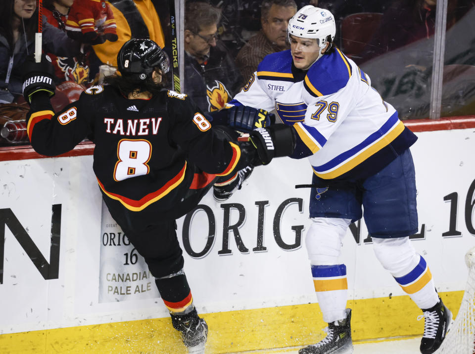 St. Louis Blues forward Sammy Blais (79) checks Calgary Flames defenseman Chris Tanev (8) during the second period of an NHL hockey game in Calgary, Alberta, Tuesday, Jan. 23, 2024. (Jeff McIntosh/The Canadian Press via AP)