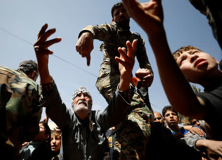 A man who fled eastern Ghouta gestures as he receives aid from Russian forces at a shelter in Adra, near Damascus, Syria, March 20, 2018. REUTERS/Omar Sanadiki