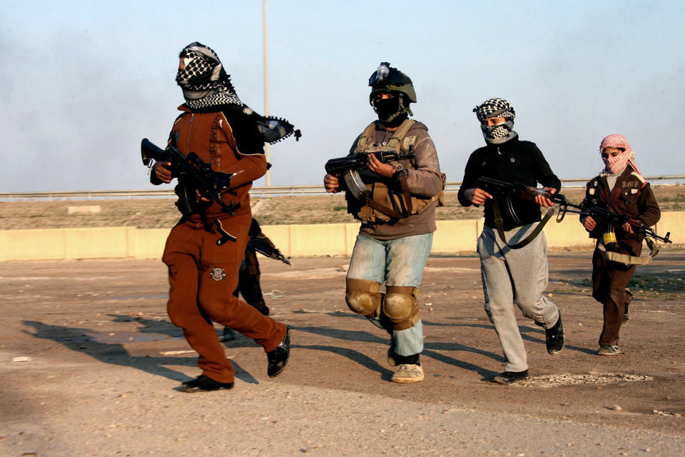 In this Wednesday, Jan. 15, 2014 photo, gunmen hold their weapons as they patrol Fallujah, 65 kilometers (40 miles) west of Baghdad, Iraq. Iraqi airstrikes pounded a town near Fallujah that had been seized by al-Qaida linked militants and commandos swept in Wednesday to clear the area, senior military officials said. It was a rare victory for government forces that have been struggling for nearly three weeks to regain control of the mainly Sunni area west of Baghdad. (AP Photo)